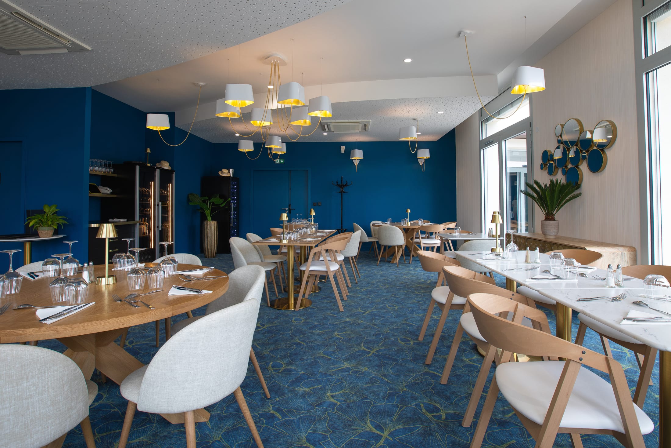 Salle lumineuse du restaurant Chez Cladie dressée pour le déjeuner